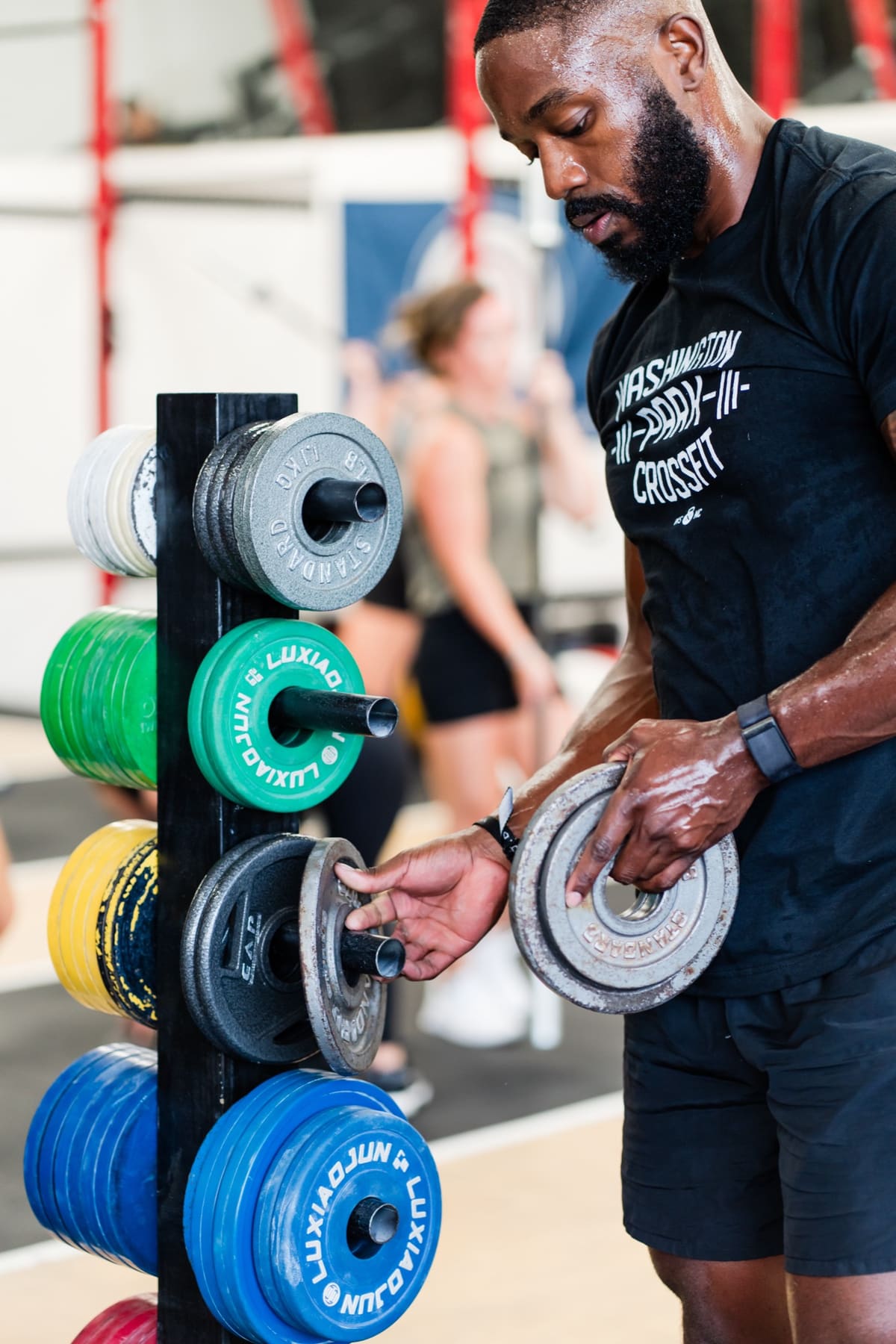 Members gathered in front of the Washington Park CrossFit logo wall